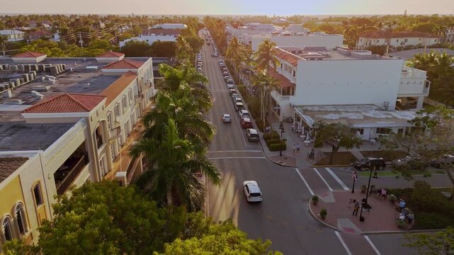 Naples Florida afternoon aerial showing 5th Avenue with luxury shops, palm trees and tourists. The orbits across 5th avenue showing boutique shops and palm tree lines avenue.