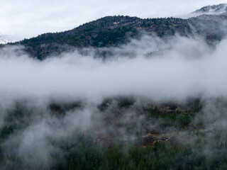 Misty Mountains Over a Foggy Valley in BC, Canada With Dense Forest and Cloud Cover