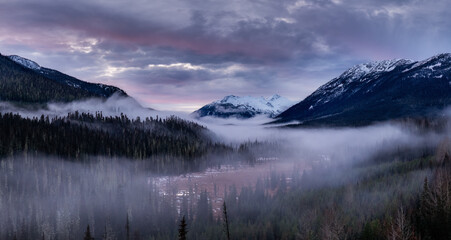 Fototapeta premium Snowy Mountain Valley With Foggy Forest at Dawn in British Columbia, Canada