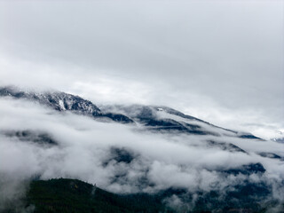 Mist Shrouded Mountain Range in Clouds Over Snowy BC Landscape, Canada