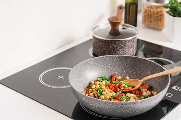 Frying pan with tasty vegetables on electric stove in kitchen, closeup