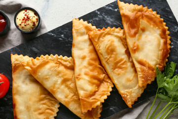 Many tasty chebureks on dark board