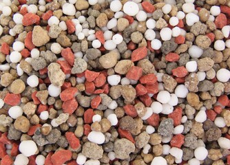 Closeup of granular fertilizer for plants known as NPK, or a combination of nitrogen, phosphorus...