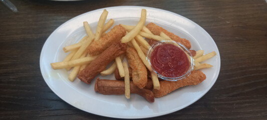 fried potatoes and sausages with tomato sauce