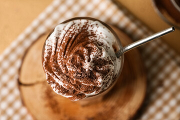 Fototapeta premium Glass of cocoa drink with whipped cream and powder, closeup