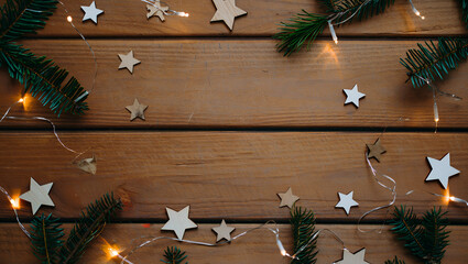Holiday decorations with wooden stars and pine branches on wood