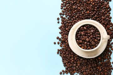 Cup with coffee beans on blue background