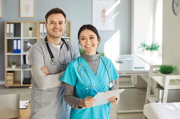 Happy health care coworkers posing, clinic staff teammates, young doctor and nurse, skilled medic group colleagues interns, diverse team of practitioners portrait, two friendly clinic employees