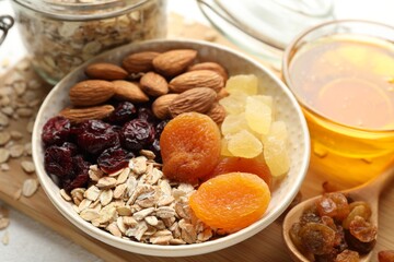 Making granola. Oat flakes, dried fruits and other ingredients on white table, closeup