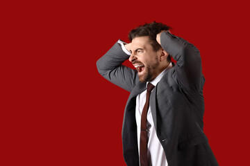 Angry businessman shouting on red background