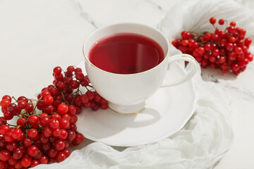 Cup of hot viburnum tea on marble background