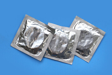 Condom on blue background. Top view