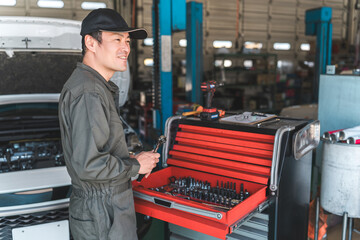 A middle-aged Asian man working as a mechanic, car mechanic, or mechanic at a repair shop