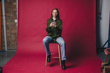 Confident female speaker with smartphone in vibrant studio setting