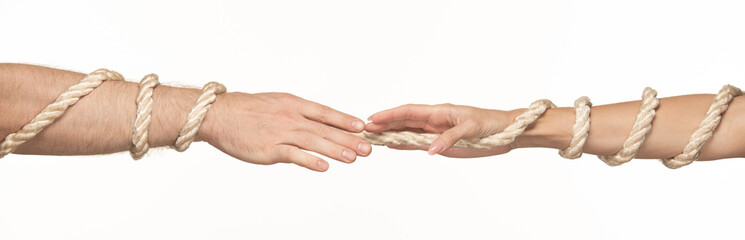 a woman's and a man's hands want to reach each other, tied with a rope