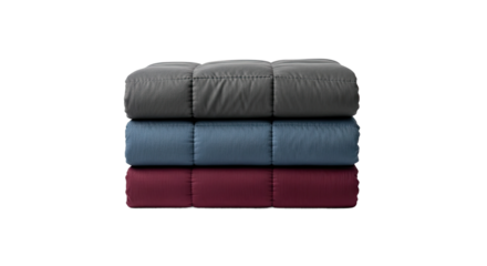 A neat stack of three folded and quilted comforters in grey, blue, and burgundy colors, showcasing cozy and warm bedding for a comfortable and stylish home interior