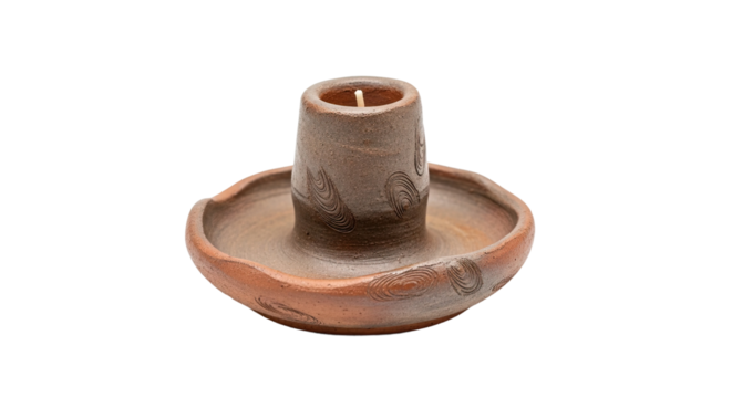 An antique-style handmade clay candlestick holder with a rough texture and etched swirl decorations, featuring a single unlit candle with a visible wick