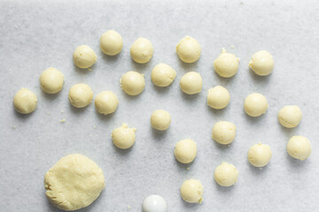Overhead view of milk balls on a white tray, top view of nigerian gullisuwa on a plate, process of making Gullisuwa, a popular snack from northern Nigeria