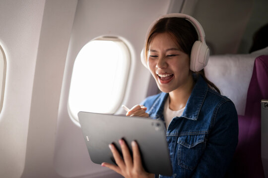 Young woman enjoying entertainment on a tablet during flight