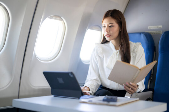 Woman working on tablet and reading during flight