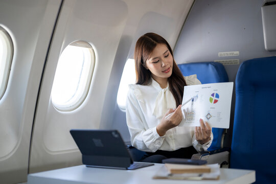 Businesswoman working on presentation flying in airplane