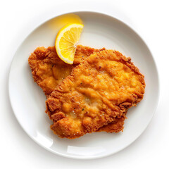 Two golden brown, crispy breaded schnitzel cutlets served on a white plate with a fresh lemon wedge garnish, isolated on white background