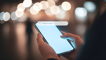 A person's hands holding a smartphone with a search bar on the screen against a blurry city lights background at night.
