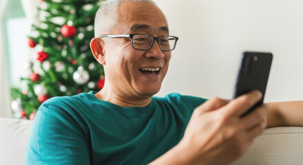 A man is smiling while holding a cell phone