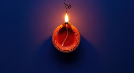 A single traditional diya casting a warm glow on a deep blue surface creating serenity and peace