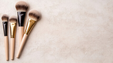 Soft makeup brush set with gold ferrule and neutral handles on textured background