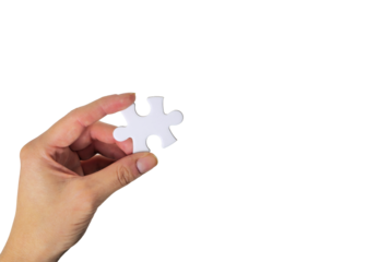 Hand holding a white jigsaw puzzle piece as a symbol of solution