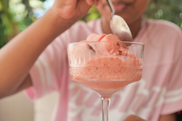 a child enjoying a refreshing strawberry ice cream in a sunny garden