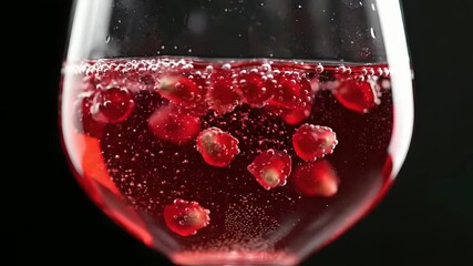 Sparkling Red Wine with Pomegranate Seeds in a Glass on Black