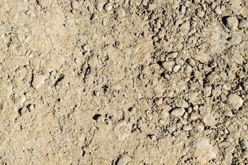 Dusty ground surface with small rocks and fine particles in natural setting on a clear day