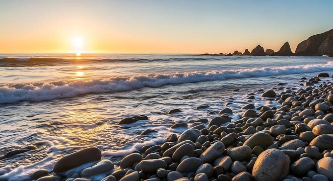 Golden sunset over the ocean with rocky beach and waves.