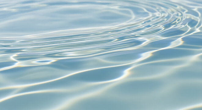 Close-up of clear pale blue water ripples reflecting bright sunlight