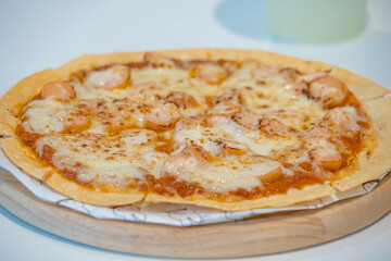 Close-up of a freshly baked cheese pizza with grilled chicken pieces and melted mozzarella toppings