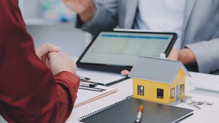 Real estate agent presenting data to client on tablet during house contract signing - Powered by Adobe