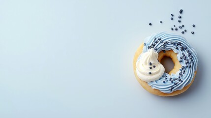 A single donut with blue frosting, a dollop of white cream, and dark sprinkles is placed on a plain light blue surface.