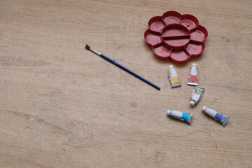 watercolor paints and brush on a wooden table