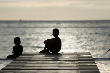 Children enjoy the sunset at the seaside pier