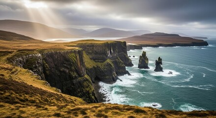 Obraz premium Dramatic coastal cliffs with sea stacks and golden light illuminating rugged landscape in Scotland