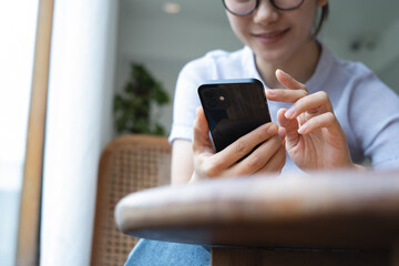 Asian woman using smartphone for social network. Woman using mobile phone for online shopping and digital banking via mobile app, closeup
