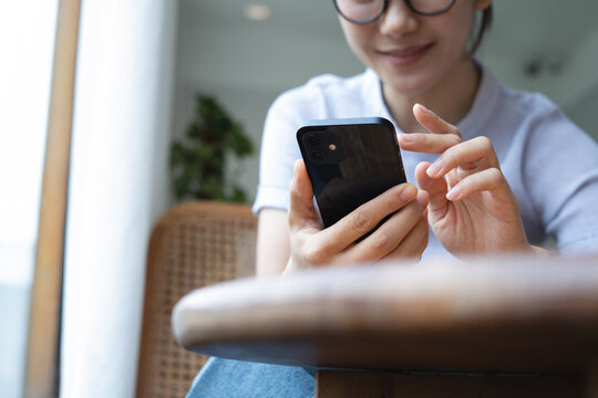 Asian woman using smartphone for social network. Woman using mobile phone for online shopping and digital banking via mobile app, closeup