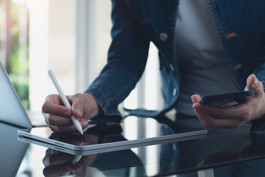 Close up, business woman using digital tablet with laptop computer on office table. Website designer, entrepreneur working on digital tablet, freelance at work, business technology - Powered by Adobe