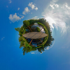Tiny Planet: footbridge over a forest river on a sunny day
