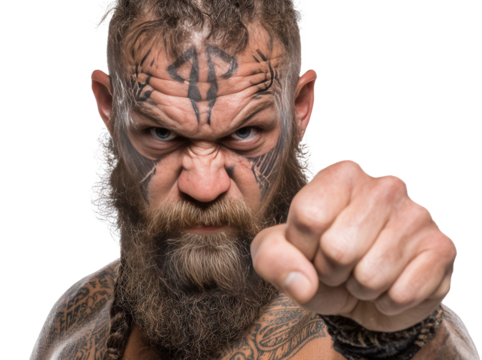 Fierce warrior posing with intense expression and tattooed features in studio setting