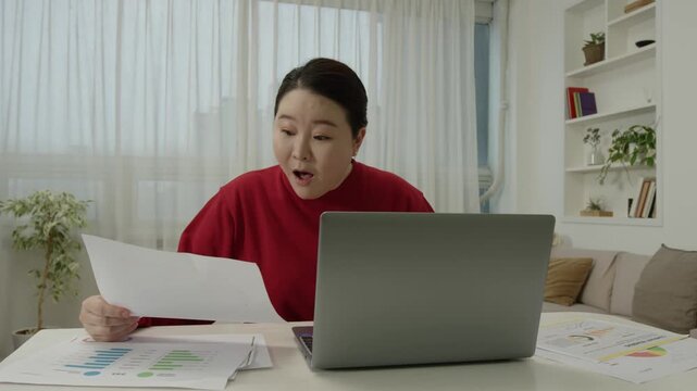 Excited woman celebrating good news after reading document at home