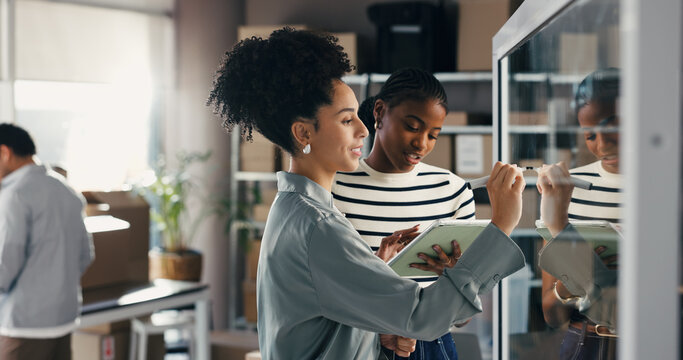People, writing and talk with tablet at glass wall for brainstorming ecommerce, logistics and shipping. Team, discussion and research in office with tech, supply chain strategy and distribution plan.