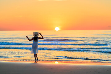 夕焼けの海を眺める彼女
